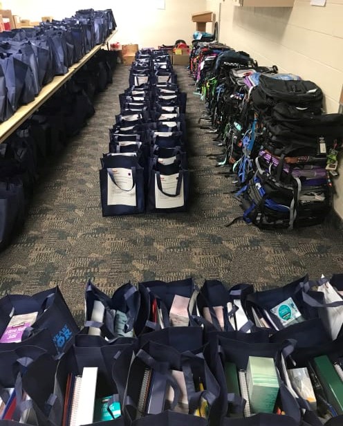 Photo of school supplies lined up on the floor.