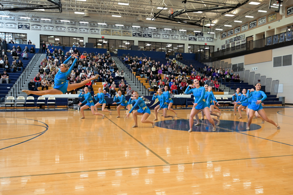 Eden Prairie Dance Team performing a routine. One athlete is leaping in the air. Contributed photo