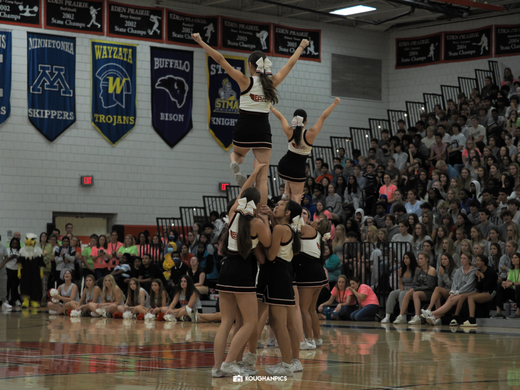 Eden Prairie High School (EPHS) cheerleaders perform a stunt in gymnasium.