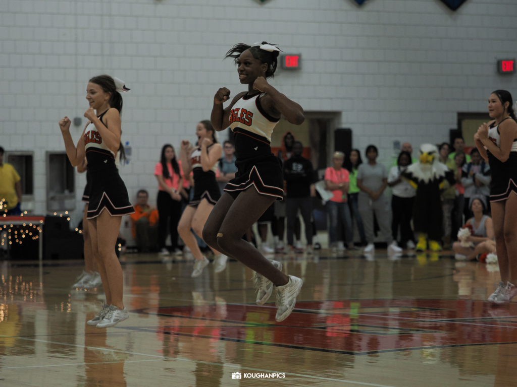 Eden Prairie High School (EPHS) cheerleader performs a jump in gymnasium.