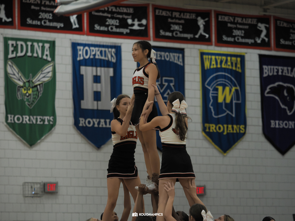 Eden Prairie High School (EPHS) cheerleaders form a pyramid in gymnasium.